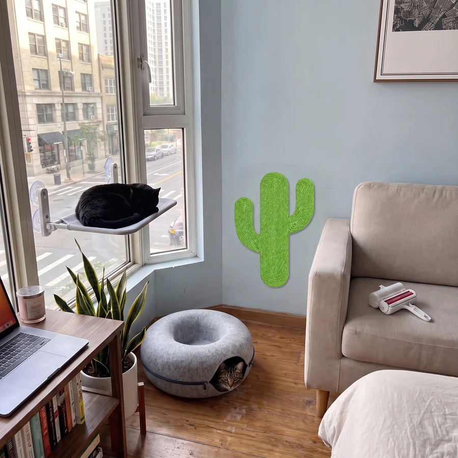 A cat window perch, a green cactus wall scratcher, a felt cat cave and a pet hair roller in a small studio apartment: the Apartment Cat Kit