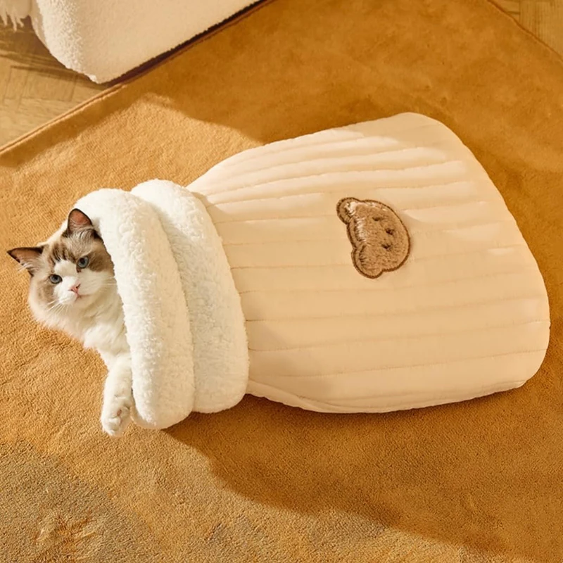 A cat lying in the opening of The Snuggle Sack cat sleeping bag